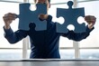 © Syed Ali Raza - businessman holds in hand a jigsaw puzzle for partnership teamwork, collaborate of partner and alliance or business connection. Business solutions, success and strategy concept.
