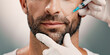 © Jess B/peopleimages.com - Hands, man and face injection in studio of skincare, facelift cosmetic and anti aging treatment. Person, needle and beauty procedure with dermal filler, facial implants and change on white background