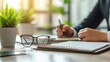 © Chaikit - Executive desk composition, business hands working position, elegant stationery arrangement, frameless eyeglasses, spiral notebook, indoor plant detail, monochromatic style, commercial photography