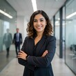 © Joa - Una mujer de negocios con los brazos cruzados en su oficina. Una mujer de negocios con poses confiables y traje.