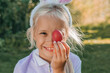 © ADDICTIVE STOCK - Child with bunny ears holding a colorful Easter egg outdoors