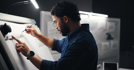Leinwandbilder - Drawing, creative and man artist in studio at night with deadline for animation illustration. Board, equipment and male graphic designer sketching for visual character prototype at agency in dark.