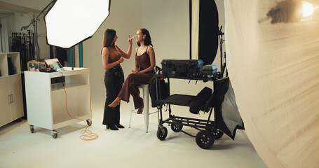 Poster - Photography, backstage and model with makeup artist in studio for production, preparing or photoshoot. Creative, media and female person with beautician for magazine editorial with behind the scenes.