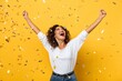 © DND - Studio shot of an excited woman celebrating a big win, surrounded by tinsel confetti, against a yellow background. (Prize)