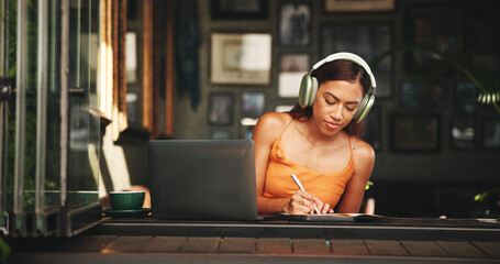 Leinwandbilder - Writing, headphones and laptop with student in cafe on campus for college research, education or learning portal. University, music and notebook with woman in restaurant for online scholarship
