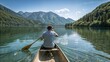 © Maxim - A man seen from the backside having a trip on a canoe in crystal clear mountain lake.