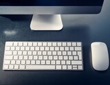 Un teclado y mouse inalámbricos sobre un escritorio moderno