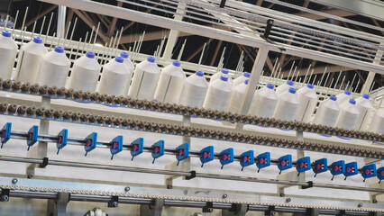 Poster - A machine is weaving a piece of fabric. The machine is made up of many parts, including a large metal piece that is connected to a hose