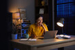 © New Africa - Woman working on laptop at desk in home office