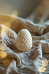 Poster - Decorative egg on soft fabric with warm bokeh lights in a cozy indoor setting