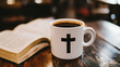 © Blurred Ink - White coffee mug with Christian cross and open Bible on wooden table, faith and devotion