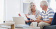 © peopleimages.com - Senior, happy couple and documents with laptop for financial planning, profit or retirement annuity on sofa. Elderly man, woman or house with computer or paperwork for pension fund or home insurance