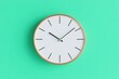 © KUTIL KURO - Minimalist wall clock on a vibrant teal background.  A clean, modern design with a simple white face and light bronze frame.  Precisely calibrated hands indicate the time