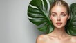 © si9nzation - Natural beauty portrait of woman with flawless skin fresh makeup and green leaves on grey background
