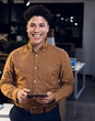 © Wavebreak Media - Smiling businessman holding tablet in modern office during evening work session