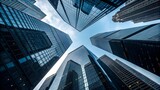 Upward perspective of modern glass skyscrapers reaching into a blue sky, highlighting advanced urban planning, corporate hubs and the sleek design of metropolitan architecture