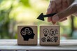 © Abd - Hand moves arrow between wooden blocks showing brain and ideas.