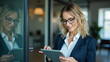 © HaJung - Empowered Female Executive in Office: Harnessing Digital Tools for Success with Tablet in Hand - A Visionary Leader's Drive Reflected in Glass | Stock Photo Concept with Space for Text