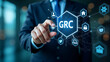 © HaJung - Flat Businessman interacts with GRC icons on digital interface representing governance risk management compliance and business ethics in organizational management. concept as Businessman interacts wit