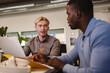 © PintoArt - Two businessmen collaborating on a project in modern office