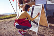 © Wavebreak Media - Woman updating menu on chalkboard at food truck, preparing for customers