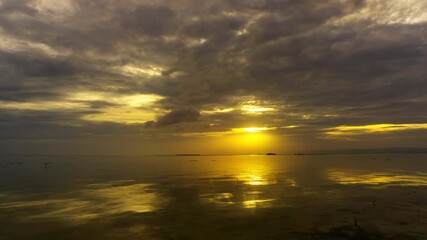 Wall Mural - sunset over calm waters creates a serene atmosphere with golden reflections and dramatic clouds, tim