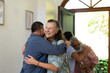 © Wavebreak Media - Diverse senior friends greeting friends with warm hugs at home, enjoying joyful reunion