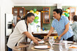 © Wavebreak Media - Setting table for celebration in kitchen, women smiling and chatting, at home