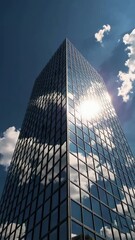 Poster - Reflective skyscraper with moving clouds and sunlight creating dynamic patterns