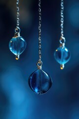Poster - A pair of blue glass balls suspended from a chain, great for decorative purposes or as a prop in photography shoots