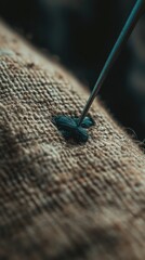Poster - A detailed shot of a needle resting on a piece of cloth, often used for sewing or crafting