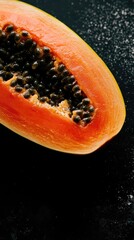 Poster - A papana fruit cut in half, placed on a dark background