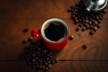 Poster - A red cup of black coffee sits on a wooden table, surrounded by scattered coffee beans. A part of an espresso maker is also visible.
