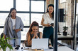 © Wavebreak Media - Celebrating success, woman with diverse female colleagues around laptop in office