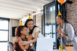 © Wavebreak Media - Celebrating success, diverse female colleagues in party hats and holding balloons in office, smiling