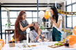 © Wavebreak Media - Diverse female colleagues celebrating birthday with cake and balloons in modern office setting