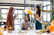 © Wavebreak Media - Female diverse colleagues celebrating birthday in office with cake and balloons, smiling happily