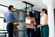 © Wavebreak Media - Diverse business team celebrating colleague receiving award in modern office