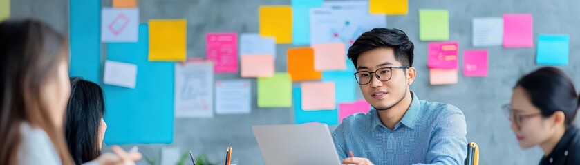 Poster - Young east asian entrepreneur in meeting room with laptop surrounded by group of people engaged in discussion