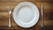 © Perabot - Empty white plate, fork, and knife on wooden table