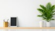 © Sirilak - Activity routine productivity Balance. A minimalist workspace featuring a tablet, a coffee cup, and a potted plant on a wooden shelf against a plain wall.
