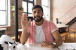 © Wavebreak Media - Smiling man in casual shirt waving during video call in modern office