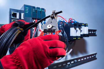 Poster - hands of electrician wire and pliers in hands of electrician. trimming wires for installing electric