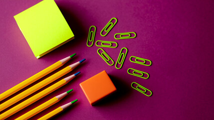 Aufkleber - Flatlay of colored pencils, paper clips, sticky note, and eraser on purple background, showcasing vibrant stationery items, perfect for school, office, or creative projects, with free space for text