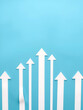 © Michael - Blue background with a series of arrows pointing upwards. The arrows are spaced out and appear to be connected to each other. Concept of growth and progress