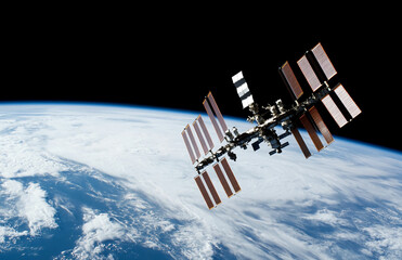 international space station orbiting earth with solar panels visible against deep outer space backdr