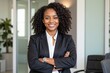 © velikiyzayats - Confident African American Woman in Professional Attire Smiling at the Office with Arms Crossed, Radiating Leadership and Positivity