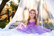 © Austockphoto - little kid playing imagine game dressed up as princess in purple dress