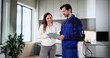 © Andrey Popov - Smiling Pest Control Worker Discusses Invoice