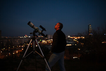 Wall Mural - amateur astronomer looking at the evening skies, observing plane